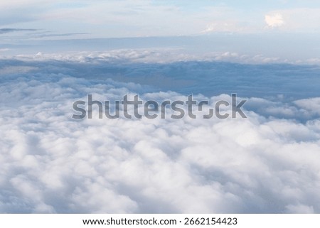 High altitude view of a dense layer of white clouds. Cloudscape from above, showcasing the texture and density of the clouds