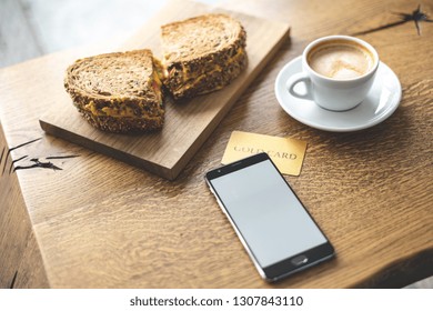 High Angle Above Top View Close Up Photo Of Portable Telephone Equipment, Snack And Beverage On Wooden Table Inside Loft Interior Space In Restaurant