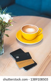 High Angle Above Top View Or Overhead, Flat Lay And Vertical Photo Of Modern Digital Smartphone With Two Credit Card Lying On Wooden Table In Cafe With Comfort And Bright Interior