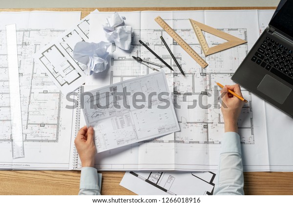 High angle above top\
view cropped clever professional lady in her formal wear she sit at\
the desk on workstation check information about building in paper\
blank or document