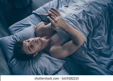 High Angle Above View Photo Of Handsome Homey Macho Guy Lying Morning Bed Alone Holding Telephone Sending Message Lover Mistress Calling Home Visit Him Sheets Room Indoors