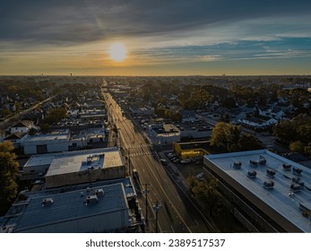 A high angle, aerial shot of a long road, reflecting the sun after a cloudy sunrise on Long Island, New York.