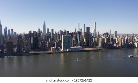 A high angle, aerial view of Manhattan from over the East River in New York. It was taken on a sunny day with clear blue skies.