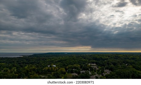 A High Angle, Aerial View Over Glen Cove, NY On A Cloudy Day In The Summer. There Are Lush Green Trees In The Upscale, Residential Neighborhood. Shot Taken By A Drone Camera.