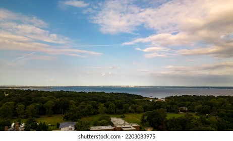 A High Angle, Aerial View Over Glen Cove, NY On A Cloudy Day In The Summer. There Are Lush Green Trees In The Upscale, Residential Neighborhood. Shot Taken By A Drone Camera.