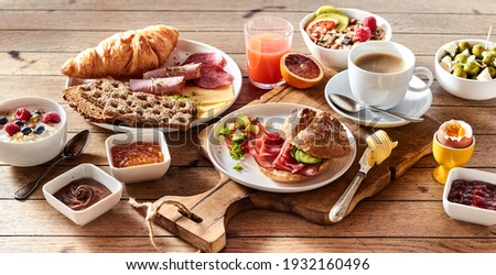 High angle of assorted appetizing food for continental breakfast placed on wooden table at home