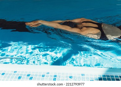 High Angle Back View Of Fit Professional Female Swimmer Swimming In Pool And Having Race During Competition 