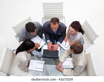 High angle of business team working together with a laptop in an office