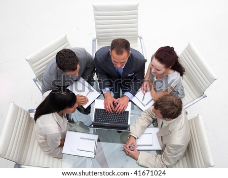 High angle of business team working together with a laptop in an office