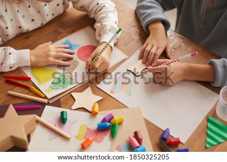 High angle close up of children tracing shapes while drawing Christmas cards in school, copy space