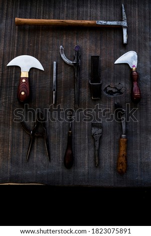 High angle close up of selection of saddle making hand tools.