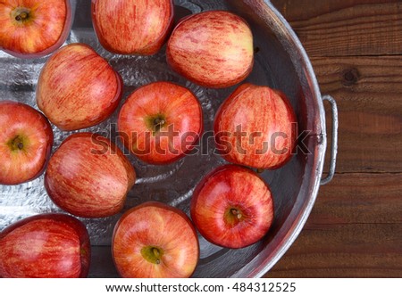High angle closeup of a metal tub filled with water and apples for the Halloween custom of Apple Bobbing.