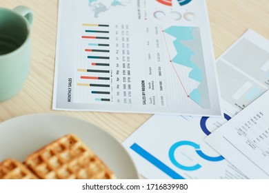 High angle close-up shot of documents and breakfast lying on kitchen table