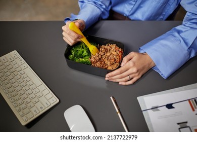 High Angle Closeup Of Young Businesswoman Eating Takeout Dinner At Desk While Working Late At Night In Office, Copy Space