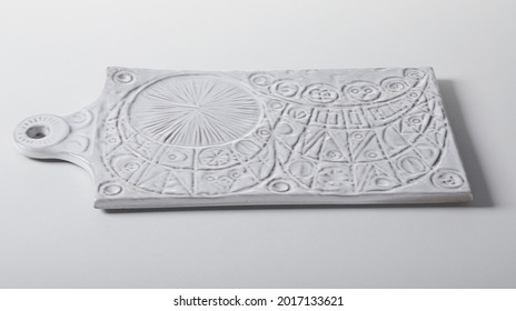 High angle of creative ceramic chopping board with abstract ornament and white enamel