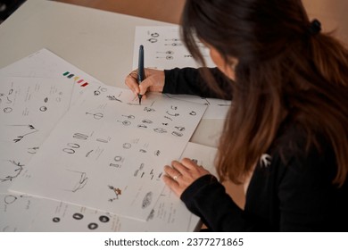 High angle of crop anonymous female designer drawing sketches for handmade accessories on paper in workshop - Powered by Shutterstock