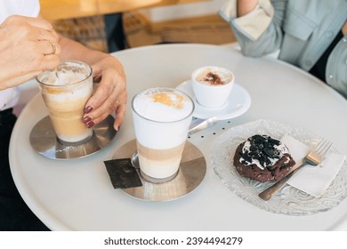 High angle of crop anonymous female sitting at round table with cups of fresh coffee while having breakfast - Shutterstock ID 2394494279