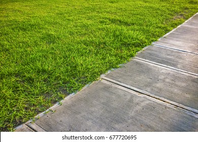 High Angle Detail Shot Of Empty Sidewalk Surrounded By Grass