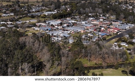 High angle drone shot showing houses, shops, and green landscape in Dorrigo, Australia.