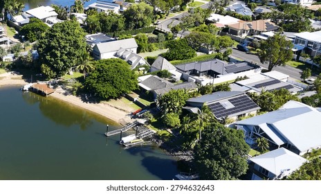 High angle drone shot of upscale residential properties with private docks and solar panels.