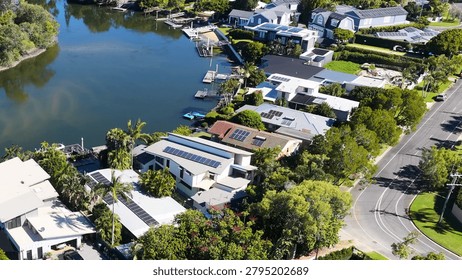 High angle drone shot of upscale residential properties with solar panels and private docks.