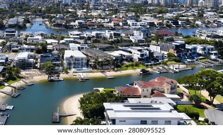 High angle drone shot of upscale residential houses with private docks along winding waterways.