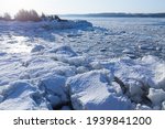 High angle east view of an icy cove in the St. Lawrence River seen in Ste. Petronille, Island of Orleans, with the south shore in the distance, Quebec, Canada