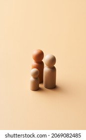 High Angle Of Figurines Of Diverse Homoparental Family With Kid Placed On Beige Background