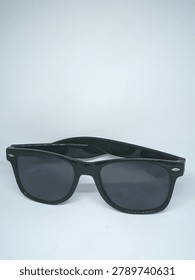 High angle front view of classic black wayfarer sunglasses with dark lenses on a white background