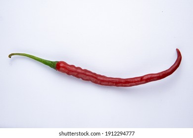 High Angle Of A Long Red Chilli On A White Table