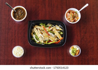 A High Angle Of Mexican Fajitas With Sliced Peppers In A Plastic Container Accompanied Rice, Salsa And Veggies