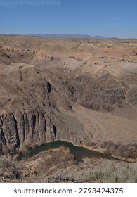 High angle panoramic view of the deep canyon floor and red rock walls at Charyn Canyon