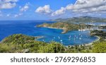 High angle panoramic view of luxury yachts at anchor in the turquoise bay of English Harbour, Antigua, seen from the iconic Shirley Heights lookout.