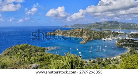 High angle panoramic view of luxury yachts at anchor in the turquoise bay of English Harbour, Antigua, seen from the iconic Shirley Heights lookout.