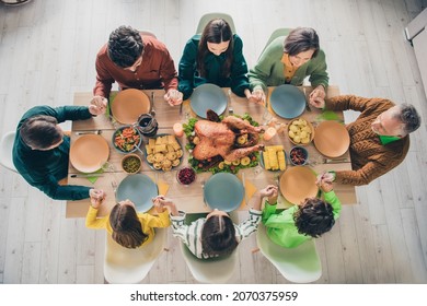 High angle photo of adorable cute family eating holiday turkey sitting table praying holding arms indoors house room - Powered by Shutterstock