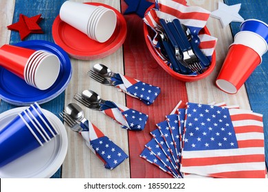 HIgh Angle Photo Of A Picnic Table Setting For A Fourth Of July Party. Plates, Cups, Napkins, And Other Items In Patriotic Red, White And Blue. Horizontal Format.