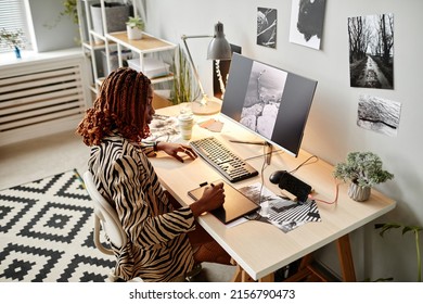 High Angle Portrait Of Black Female Creator Editing Photographs At Home Office Workplace With Graphic Prints, Copy Space