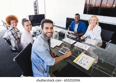 High Angle Portrait Of Business People Sitting At Confrence Table In Creative Office