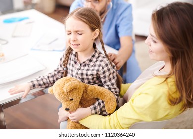 High angle portrait of cute little girl squinting with pain and fear during consultation in modern clinic - Shutterstock ID 1120364240