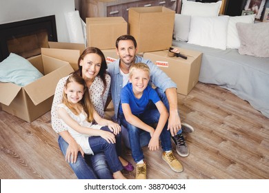 High angle portrait of family with cardboard boxes at home