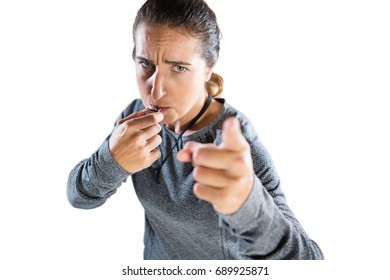 High angle portrait of female coach gesturing while whistling against white background - Powered by Shutterstock