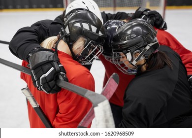 High angle portrait of female hockey team huddling for motivation before sports match - Powered by Shutterstock