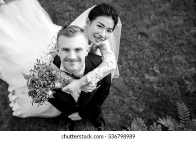 High angle portrait of happy wedding couple standing on grassy field
