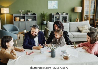 High Angle Portrait Of Modern Jewish Family Drawing Together While Sitting At Table At Home