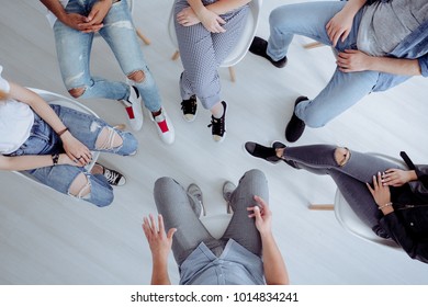 High angle of rehab specialist and rebellious teenagers sitting in a circle during a meeting