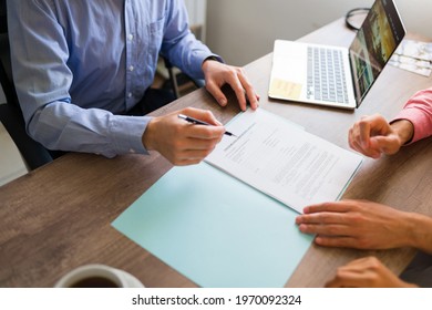 High angle of a sales representative showing a timeshare sale contract and purchase agreement to some clients sitting at their travel office 