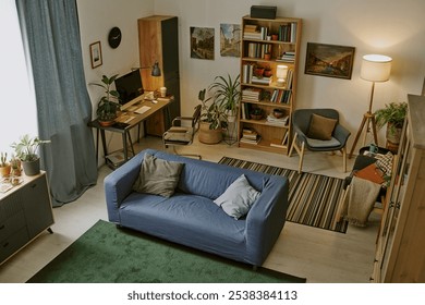 High angle shot of ample work zone with wooden furniture and huge number of book on shelves in modern living room
