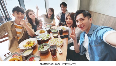 high angle shot of asian young six friends taking selfie in restaurant happily