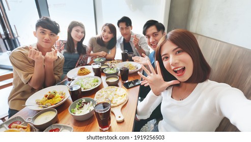high angle shot of asian young six friends taking selfie in restaurant happily