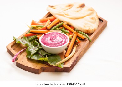 A High Angle Shot Of Beet Dip With Baked Naan Flatbread And Vegetable Sticks For Dipping